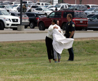 A school official comforts an emotional parent after police cleared the elementary school and found no threats, May 2, 2023. (Jordan Renfro)