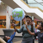 A Sci-Fi & Fantasy Expo attending family reacts to an inflatable "Earth" suspended in the air through the demonstration of the Bernoulli's principle by APSU students and their Professional Mad Scientist, Bryan Gaither, at the CMC Public Library on Nov. 2, 2024. (Daniela Thomas/APSU)
