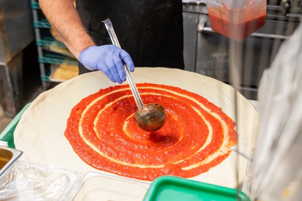Adding the sauce at Michael's Pizza and More. (Contributed)