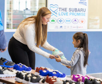 Sonja Harrell giving out shoes at the Wyatt Johnson Subaru shoe and sock giveaway on January 17, 2024. (Wesley Irvin)