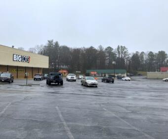 The Big Lots parking lot on Riverside Drive, with the proposed site for the apartment complex shown on the hillside at right, on Feb. 12, 2025. (Chris Smith)