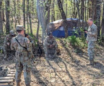 Chaplain (Maj.) Michael Dawson preaches to soldiers during a field training exercise, providing spiritual support and guidance in a tactical environment. (U.S. Army photo by Staff Sgt. David Shaffer)