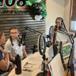 Students join Kyle King and Tiffany Hill on the air on Q108 for Q-Up the Classroom radiothon for Teachers Warehouse on July 24, 2025. (Chris Smith)