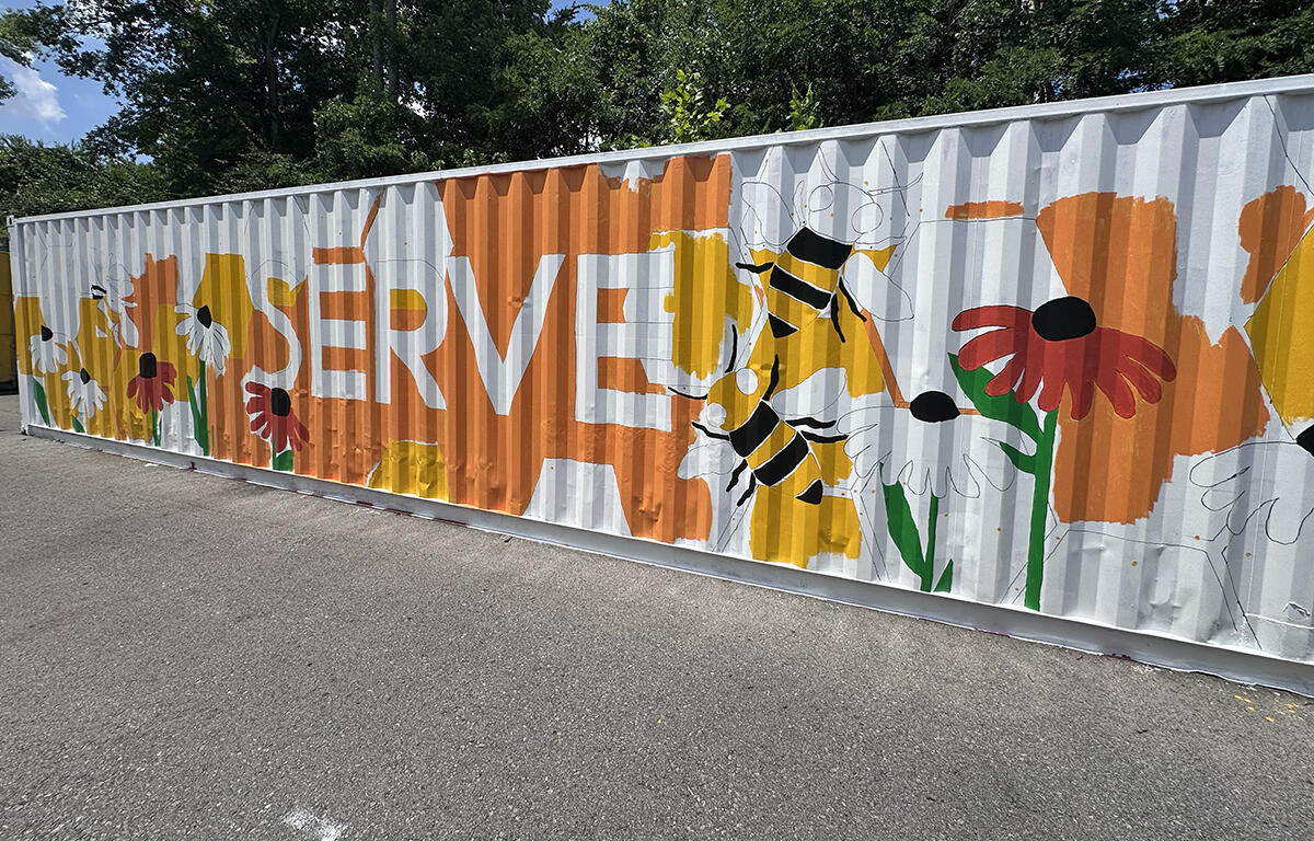 Partially-finished mural on shipping container at Loaves and Fishes on July 24