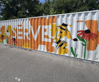 Partially-finished mural on shipping container at Loaves and Fishes on July 24