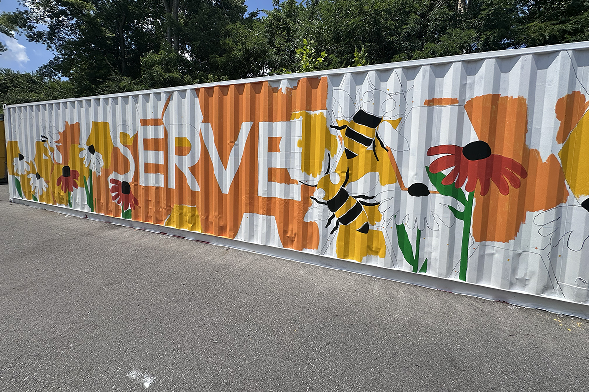 Partially-finished mural on shipping container at Loaves and Fishes on July 24