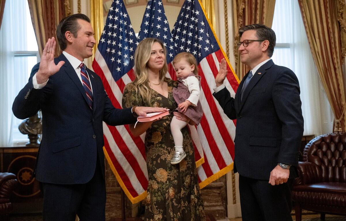 Rep. Matt Van Epps, R-Tenn, left, takes part in a ceremonial swearing-in with Speaker Mike Johnson, R-La., Thursday, Dec. 4, 2025, in Washington. Holding the Bible is Van Epps' wife, Meg Wrather, and their daughter, Amelia Van Epps. (AP Photo/Kevin Wolf)