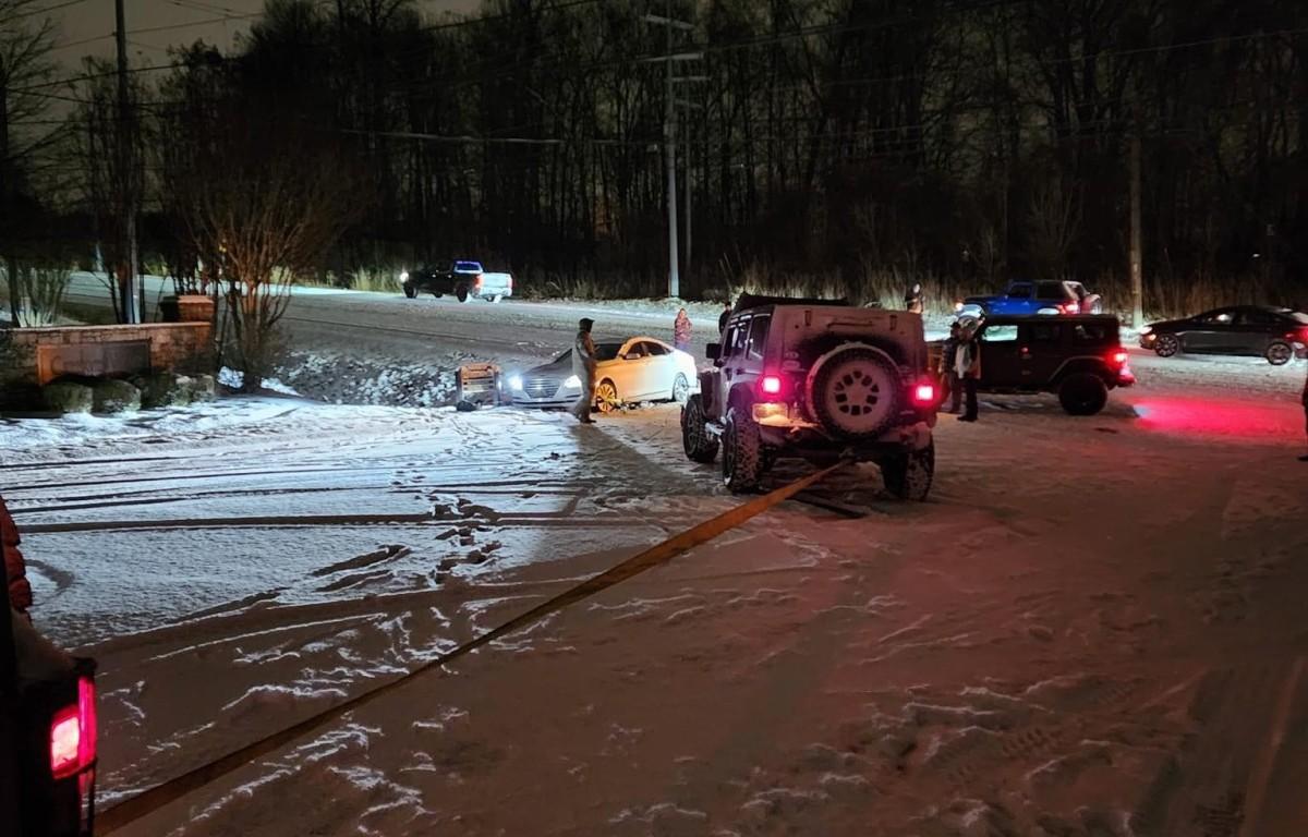 Police and Jeep drivers assist a vehicle during a previous winter storm in Clarksville. (CPD, contributed)