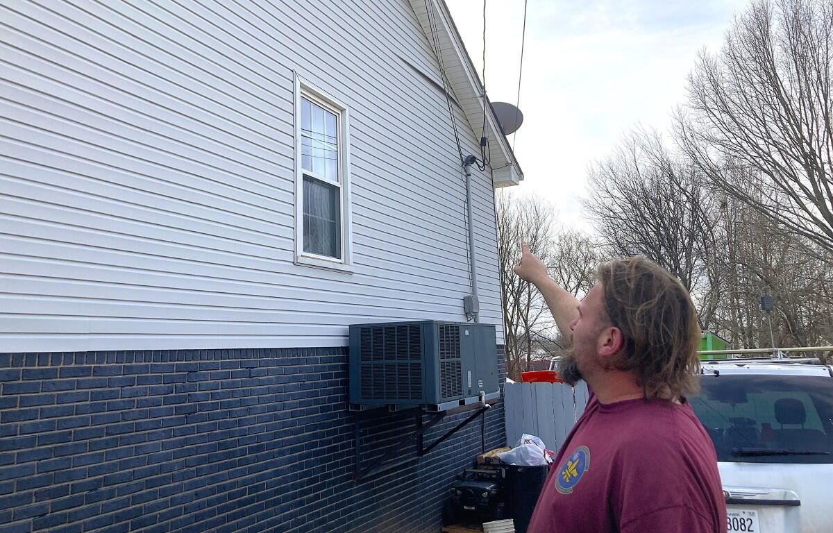 Ryan Thompson pointing out some of the damage to the side of his home. (Christian Brown)