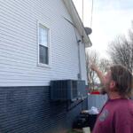 Ryan Thompson pointing out some of the damage to the side of his home. (Christian Brown)