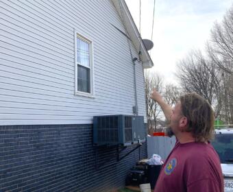 Ryan Thompson pointing out some of the damage to the side of his home. (Christian Brown)