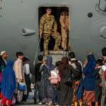 Service members stand at a doorway as Afghan evacuees prepare to board an aircraft, Aug. 22, 2021, at Al Udeid Air Base, Qatar. (Airman 1st Class Kylie Barrow/U.S. Air Force via AP, File)