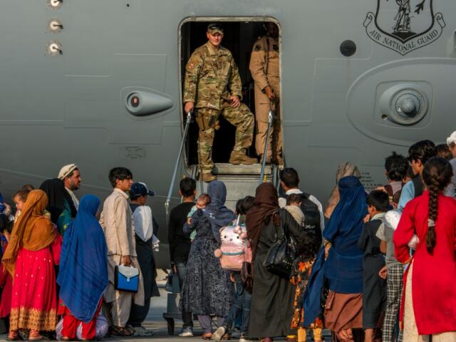 Service members stand at a doorway as Afghan evacuees prepare to board an aircraft, Aug. 22, 2021, at Al Udeid Air Base, Qatar. (Airman 1st Class Kylie Barrow/U.S. Air Force via AP, File)