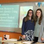 Two women pose in a classroom beside a projected slide about empowering student mathematicians in math identity research.