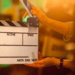 Clapperboard on a film set being held by hands, ready to slate a scene.