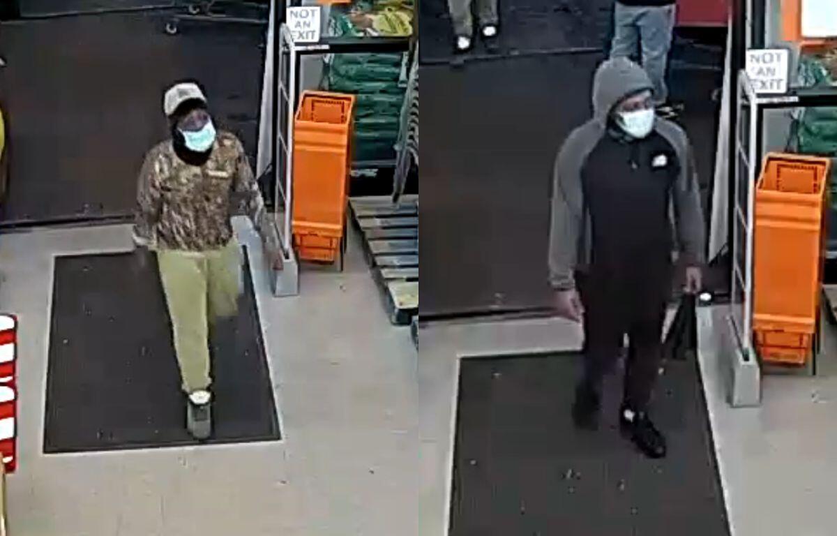 Two masked men enter a store through the entrance; left man wears camo hoodie and beige pants, white cap.