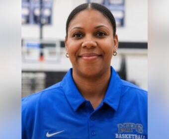 Portrait of a smiling woman in a blue MPC Basketball polo, facing the camera.