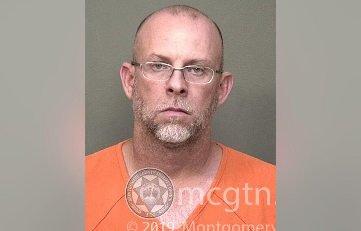 Mugshot of a bald man with glasses wearing an orange jumpsuit, facing the camera with a neutral expression; watermark from Montgomery County Sheriff's Office visible.