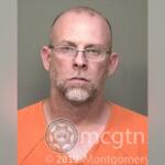 Mugshot of a bald man with glasses wearing an orange jumpsuit, facing the camera with a neutral expression; watermark from Montgomery County Sheriff's Office visible.