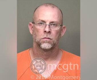 Mugshot of a bald man with glasses wearing an orange jumpsuit, facing the camera with a neutral expression; watermark from Montgomery County Sheriff's Office visible.