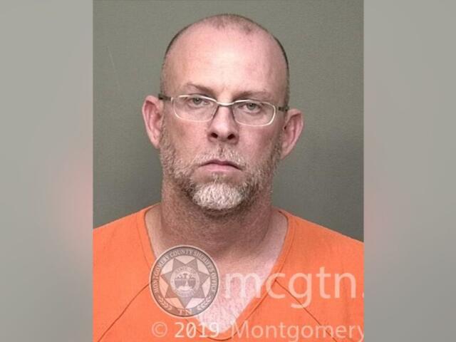 Mugshot of a bald man with glasses wearing an orange jumpsuit, facing the camera with a neutral expression; watermark from Montgomery County Sheriff's Office visible.