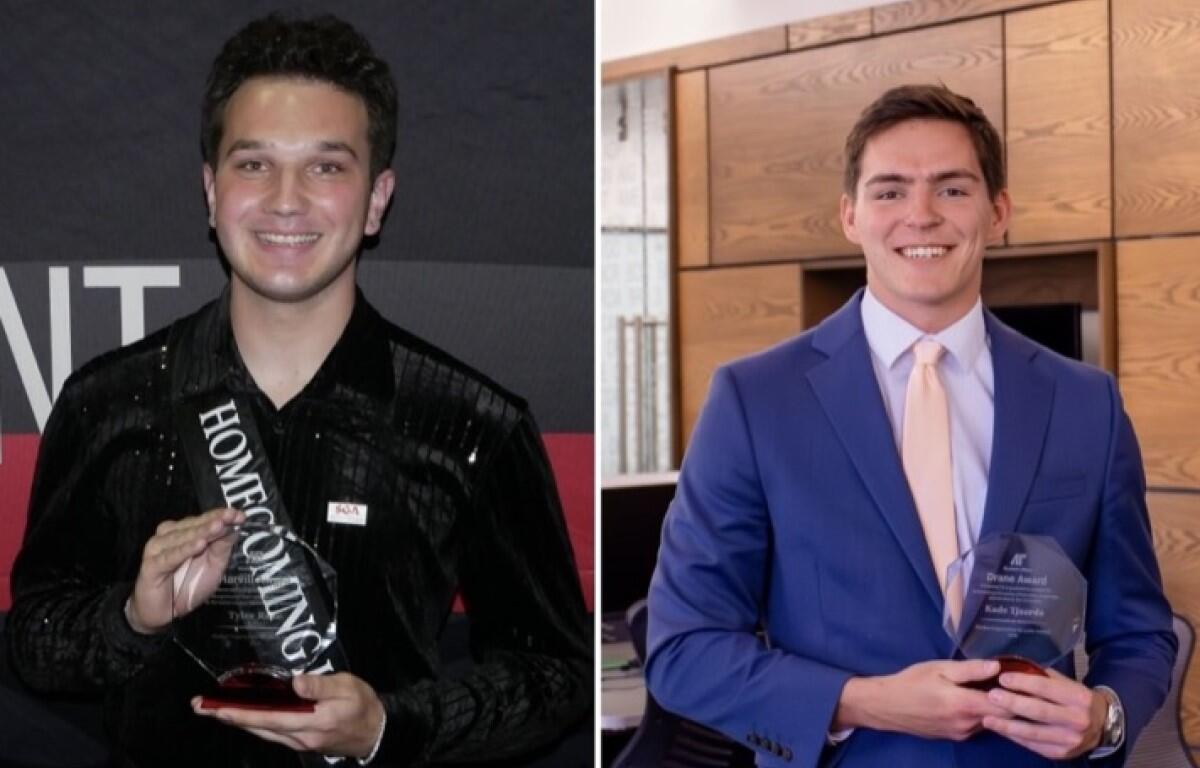 Young man in a shiny black shirt holding a crystal award with a white sash reading Homecoming on his chest. But concise: 'Young man in a shiny black shirt holding a crystal award with a Homecoming sash.'