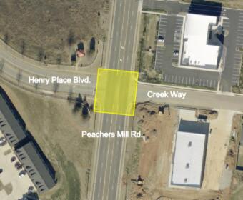 Aerial view of an intersection where Henry Place Blvd meets Creek Way and Peachers Mill Rd; a yellow square marks a lot.