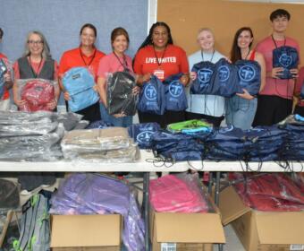 Volunteers with United Way of Greater Nashville and CMCSS Families in Transition pass out free backpacks to students and families at the Back to School Bash at Kenwood High School on Jul 18, 2026. (Lee Erwin)