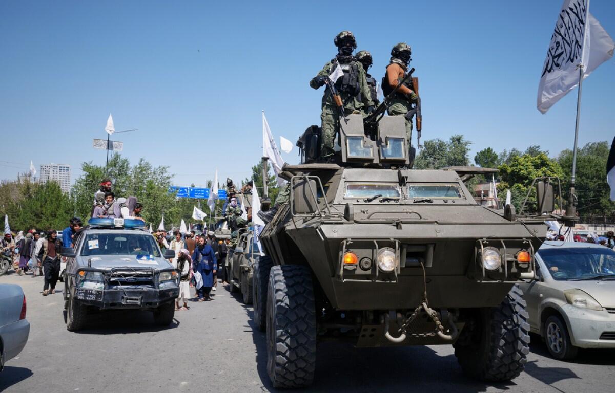 Armed Taliban ride atop an armored vehicle during celebrations marking the fifth anniversary of the U.S. withdrawal from Afghanistan and the Taliban's return to power, in Kabul, Afghanistan, Saturday, Aug. 15, 2026. (AP Photo/Siddiqullah Alizai)