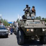 Armed Taliban ride atop an armored vehicle during celebrations marking the fifth anniversary of the U.S. withdrawal from Afghanistan and the Taliban's return to power, in Kabul, Afghanistan, Saturday, Aug. 15, 2026. (AP Photo/Siddiqullah Alizai)