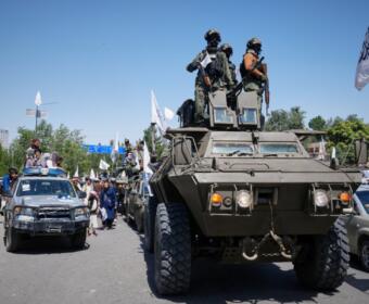 Armed Taliban ride atop an armored vehicle during celebrations marking the fifth anniversary of the U.S. withdrawal from Afghanistan and the Taliban's return to power, in Kabul, Afghanistan, Saturday, Aug. 15, 2026. (AP Photo/Siddiqullah Alizai)