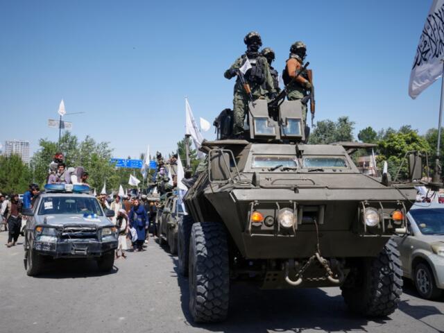 Armed Taliban ride atop an armored vehicle during celebrations marking the fifth anniversary of the U.S. withdrawal from Afghanistan and the Taliban's return to power, in Kabul, Afghanistan, Saturday, Aug. 15, 2026. (AP Photo/Siddiqullah Alizai)