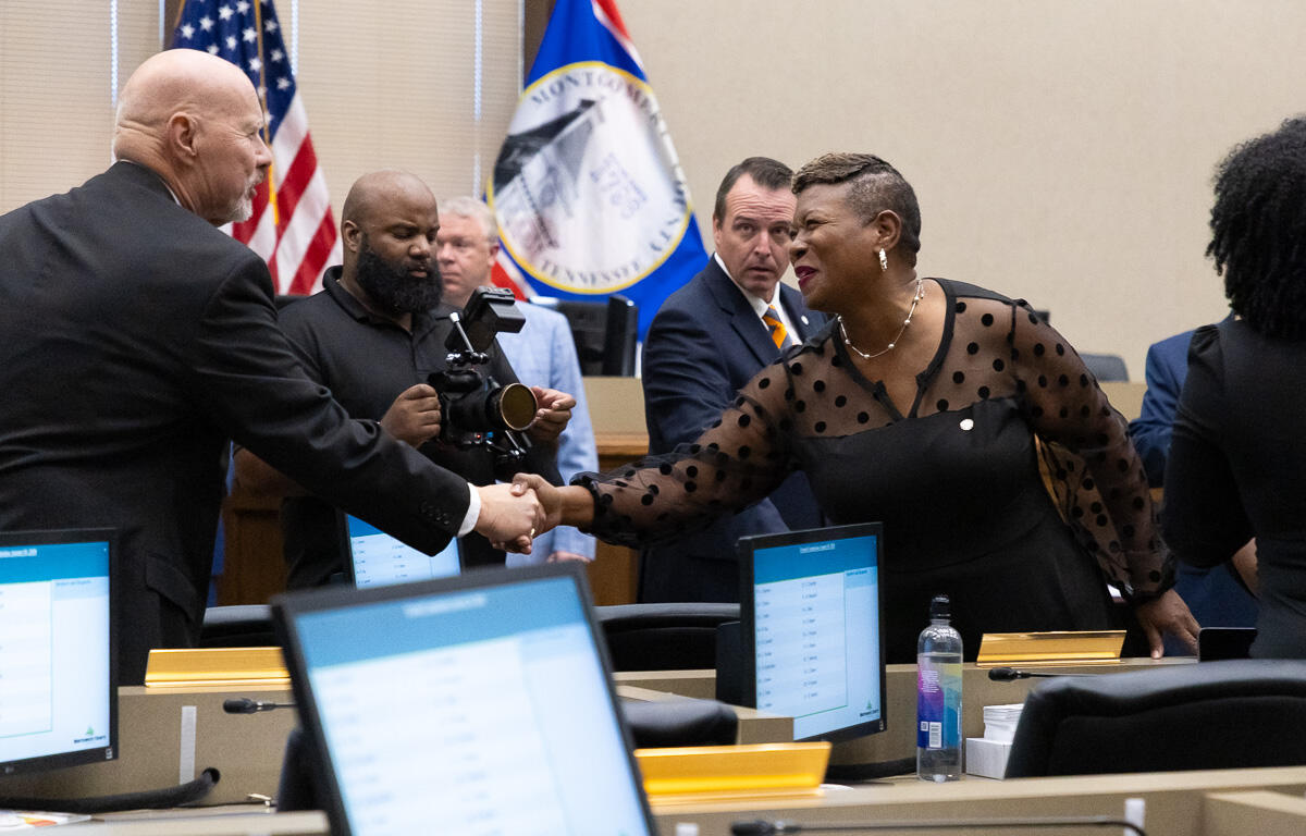 Commissioner Rashidah Leverett, right, congratulates new Commissioner Ted Denny as elected Montgomery County officials are sworn in at the Historic Courthouse on August 31, 2026 (Wesley Irvin)