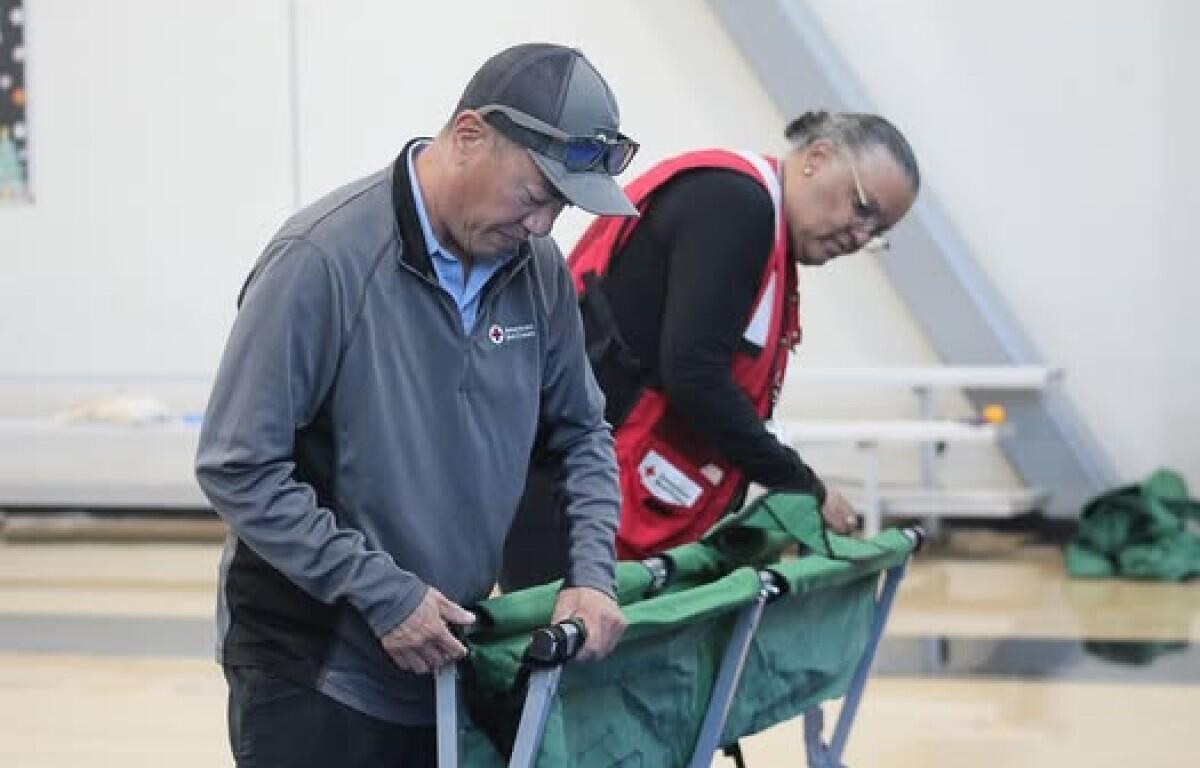 Volunteers set up beds in a Red Cross shelter. (Red Cross, contributed)